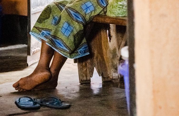 Image of a woman's feet as she sits in prison