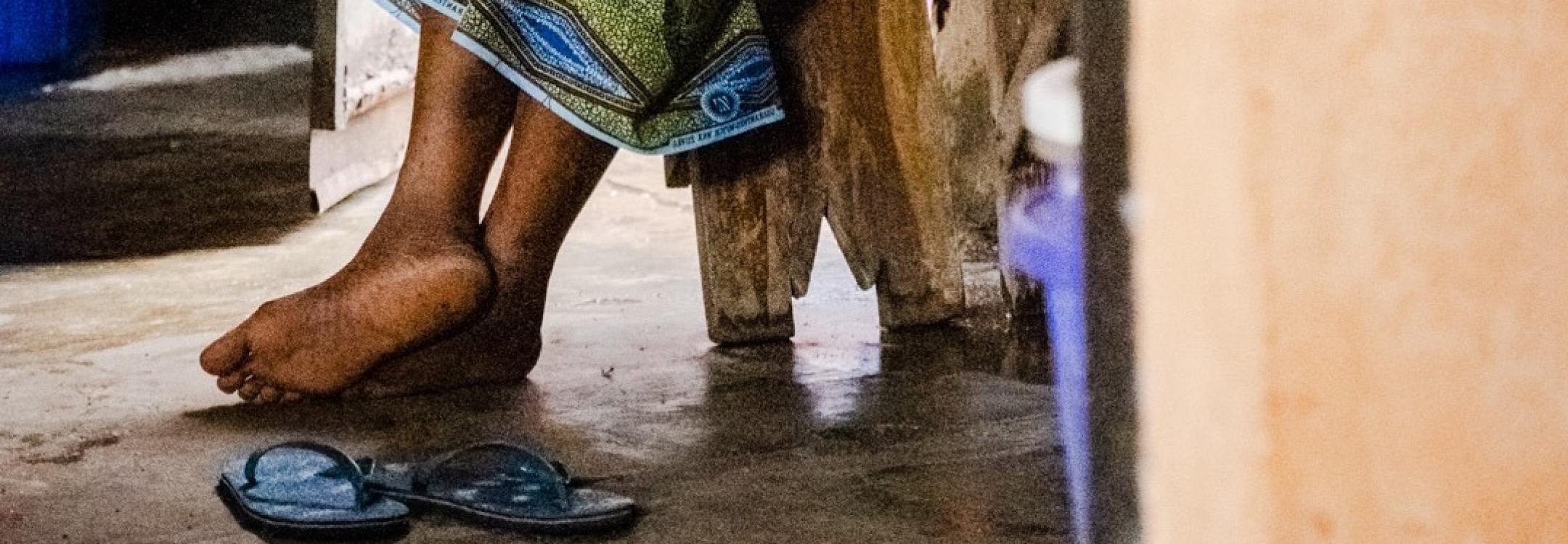 Image of a woman's feet as she sits in prison