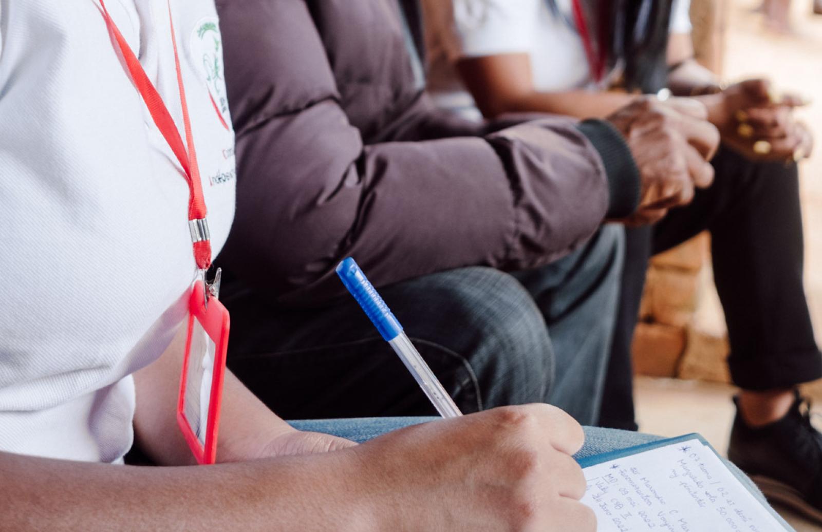 NPM member writing notes while colleague interviews detainee